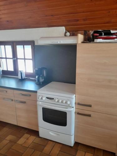 a kitchen with a white stove and wooden cabinets at Burguet in Campan