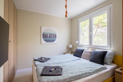 1 dormitorio con cama y ventana en Balatonic Orange en Zamárdi
