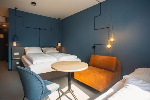 Zimmer mit 4 Betten, einem Tisch und einem Stuhl in der Unterkunft Nena Apartments Bochum City in Bochum