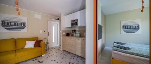 uma sala de estar com um sofá amarelo e uma cozinha em Balatonic Orange em Zamárdi