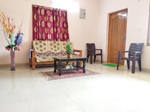 a living room with a couch and a table and chairs at SLS HOMESTAY - Luxury AC Service Apartments 1BHK, 2BHK, 3BHK - Direct Flyover to Alipiri Tirumala Gate - Walk to PS4 Pure Veg Restaurants, Supermarkets - Near to National Highway & Padmavathi Amma Temple - Modular Kitchen, Living room -Free Superfast Wifi in Tirupati