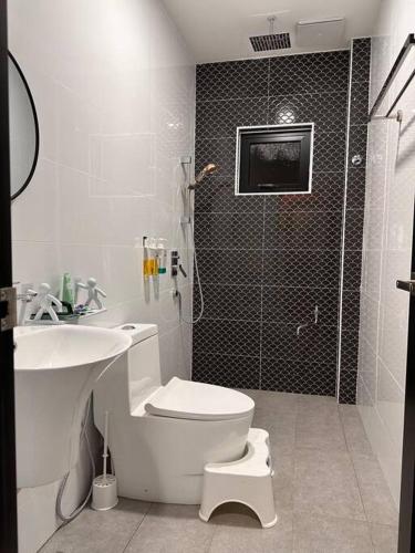 a bathroom with a toilet and a sink and a shower at Rumah Tamu Sonata in Seremban