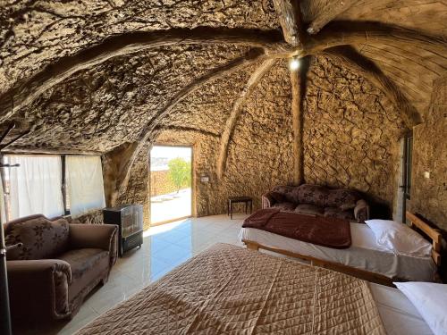 um quarto com uma cama numa parede de pedra em Al-Nawatef ECO camp- Dana Nature Reserve em Dana