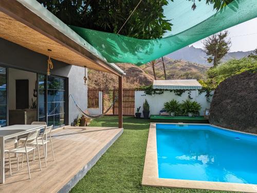 uma casa com piscina, mesa e cadeiras em Finca Pedra Molar em Órgãos