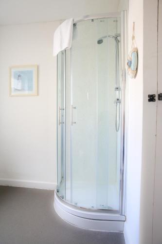 a shower with a glass door in a bathroom at Contemporary 2 Floor Flat with Sea Views! in Lowestoft