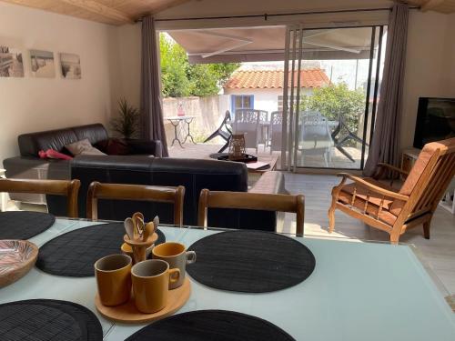 - un salon avec une table et des tasses dans l'établissement Maison proche plages, port et tous commerces, à Les Sables-dʼOlonne