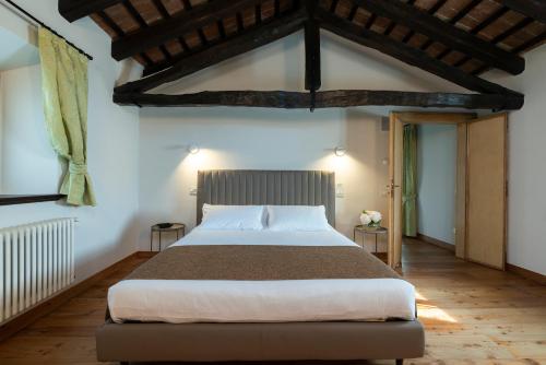 1 dormitorio con 1 cama grande en una habitación en Lis Fadis Wine Relais, en Cividale del Friuli