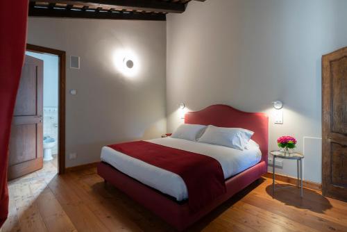 a bedroom with a large bed with a red headboard at Lis Fadis Wine Relais in Cividale del Friuli