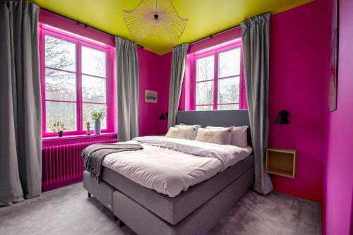 a bedroom with pink and yellow walls and a bed at Hotel Montagne in Åmmeberg