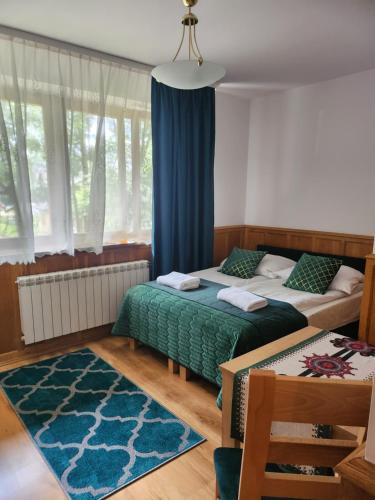 a bedroom with two beds and a blue curtain at Pokoje Gościnne Zbyszko in Zakopane