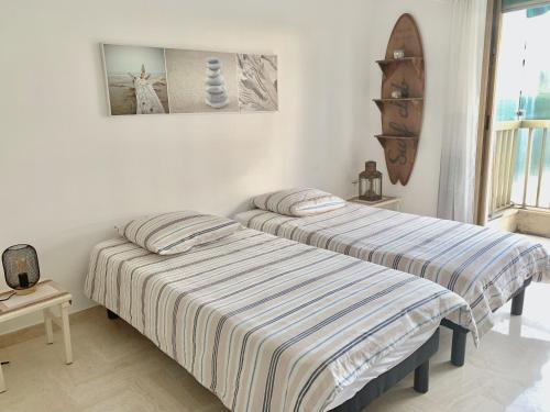 Cette chambre blanche comprend 2 lits. dans l'établissement Appartement front de mer, 80M2 (3P), Piscine & Mer, à Cannes