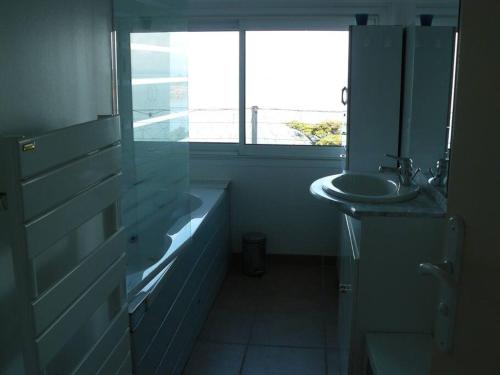 La salle de bains est pourvue d'un lavabo, de toilettes et d'une fenêtre. dans l'établissement Au dessus de l'eau, à Trébeurden