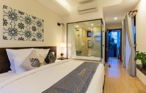 a bedroom with a large bed and a glass door at Riverside Hamlet Homestay & Villa in Hoi An