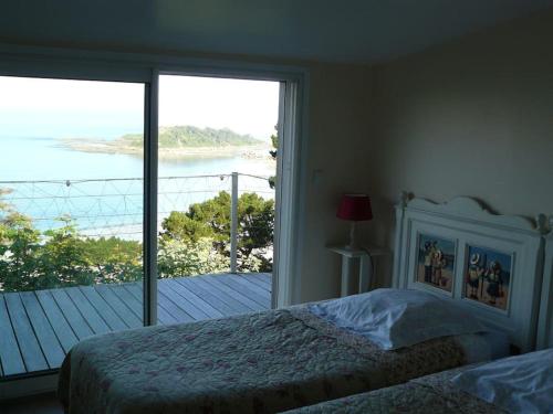 een slaapkamer met een bed en uitzicht op de oceaan bij Au dessus de l'eau in Trébeurden