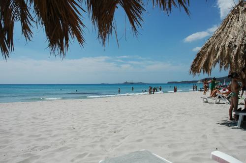 a group of people on a beach with the ocean at Residence Fenicia in Villasimius