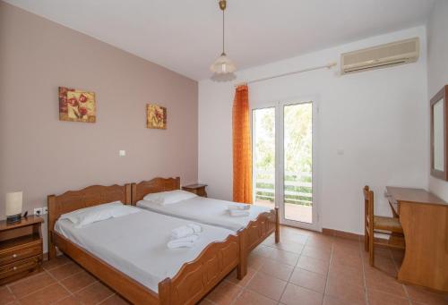 a bedroom with two beds and a window at Abby's Place in Zakynthos Town