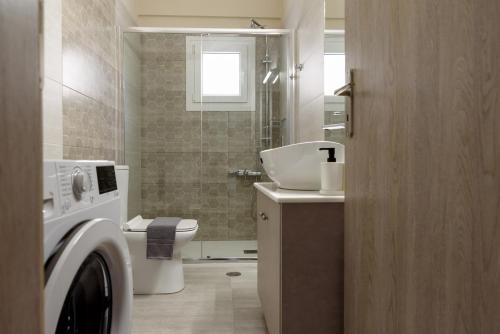 uma casa de banho com um lavatório e uma máquina de lavar roupa em Afroditi's Delux apartment em Monemvasia