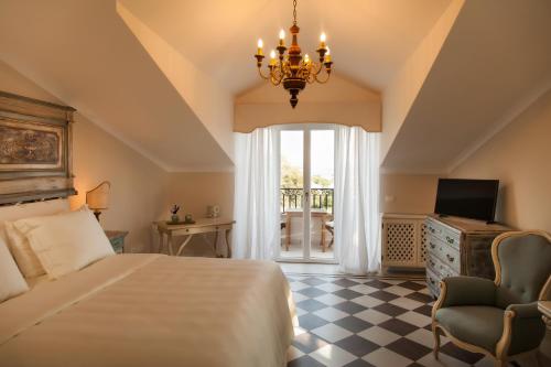 布拉恰諾的住宿－Poggio delle Molare Adults-Only Retreat，一间卧室配有一张床、一台电视和吊灯。