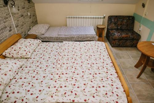 two beds in a room with a table and a chair at Sobe Tatjana in Palić