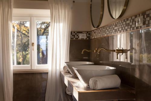 a bathroom with two sinks and a window at Poggio delle Molare Adults-Only Retreat in Bracciano