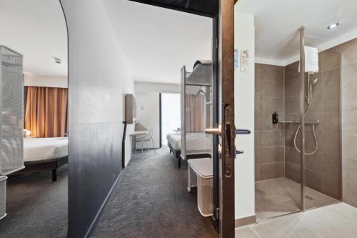 a bathroom with a shower and a room with a bedroom at ibis Styles Paris Charles de Gaulle Airport in Roissy-en-France