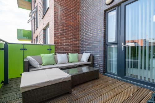 a patio with a couch and a coffee table at Gorgeous Wembley Flat in London
