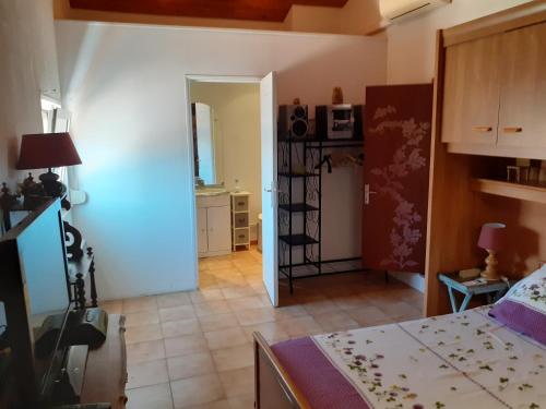 Villa Sans souci et agréable في لا سين سور مير: غرفة نوم بسرير ومطبخ في غرفة