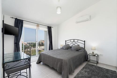 a bedroom with a bed and a large window at Villa Blue in Kyrenia