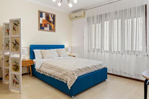a bedroom with a blue bed and a desk at Upscale Studio, Walking Distance from The Old Town in Bucharest