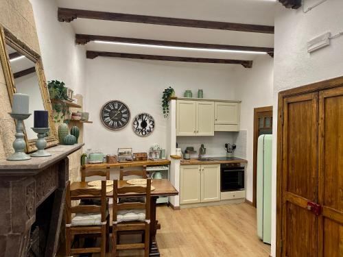 a kitchen with white cabinets and a table and chairs at All’ombra del museo in Tarquinia