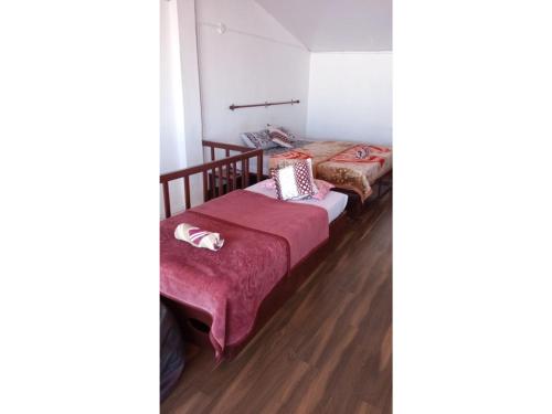 2 letti in una camera con pavimenti in legno di The Views - True Baduaga Living a Ooty