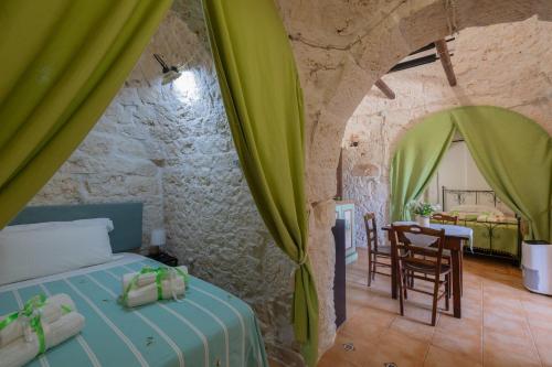 une chambre avec un lit et une table dans une pièce dans l'établissement Trullo nonna Pina, à San Michele Salentino