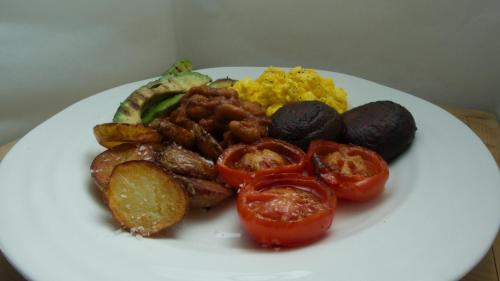 a white plate of food with tomatoes and other foods at Edgcott House in Exford
