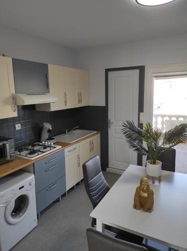 une cuisine avec un ours en peluche assis sur une table dans l'établissement APPART AU GRAU D'AGDE VUE SUR LA MER ET L'HERAULT, au Grau-dʼAgde