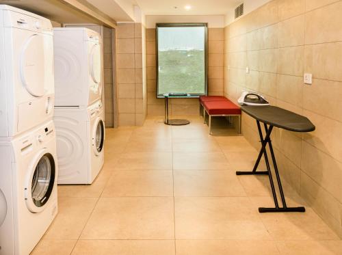 a laundry room with a washer and dryer and a table at Holiday Inn Express Kolkata Airport by IHG in Kolkata