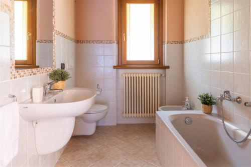 y baño con lavabo, bañera y aseo. en IseoLakeRental - Appartamento Caterina, en Ranzanico
