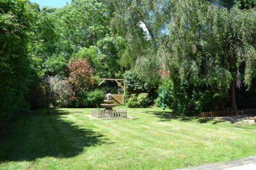 a park with a bench in the middle of a yard at Angel Valley Cottage in Brockenhurst