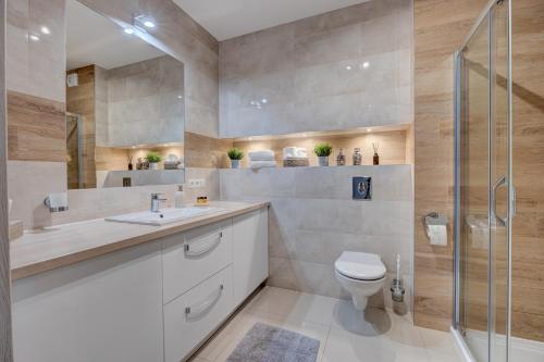 a bathroom with a toilet and a glass shower at LM Apartamenty Mariacka Stare Miasto in Szczecin