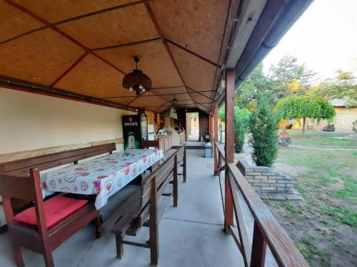 a porch of a house with a bed and benches at Pool House in Subotica