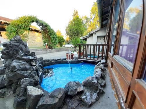 a small pond with a fountain in a yard at Pool House in Subotica