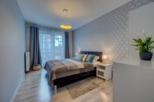 a bedroom with a king sized bed and a television at LM Apartamenty Mariacka Stare Miasto in Szczecin