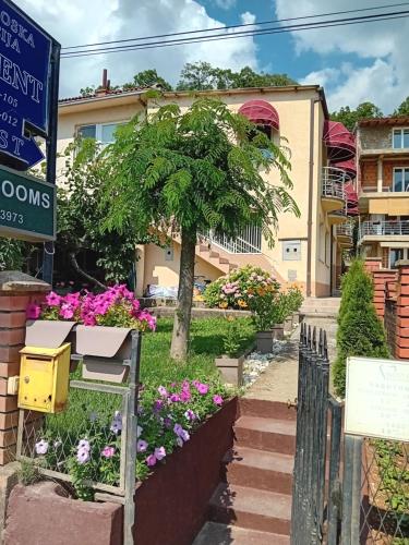 a house with flowers on the side of the street at BATO Rooms in Peštani