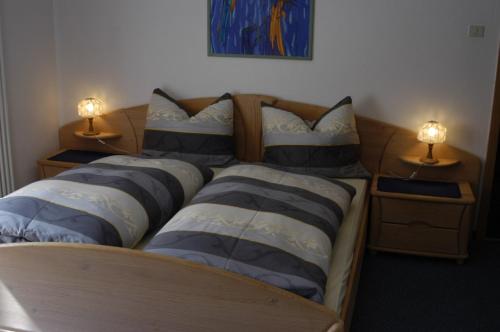 1 dormitorio con 3 camas con almohadas y 2 lámparas en HAUS Lampacher, 