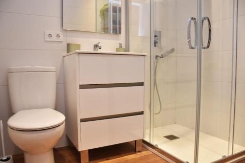 a bathroom with a toilet and a glass shower at Casa Alex Torrevieja- Holiday House - con piscina comunitaria in Torrevieja