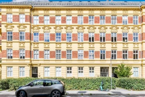 a car parked in front of a yellow building at Central Studio @Majorstuen in Oslo