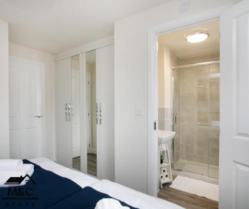 ein Schlafzimmer mit einem Bett und einer ebenerdigen Dusche in der Unterkunft Rugby Modern&3 Bed/5 guest/25%off monthly stays 