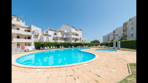 a swimming pool in front of some apartment buildings at Apt Grace 2 Bedroom Apartment with Pool and Balcony, 2,5km from Tavira Center in Tavira