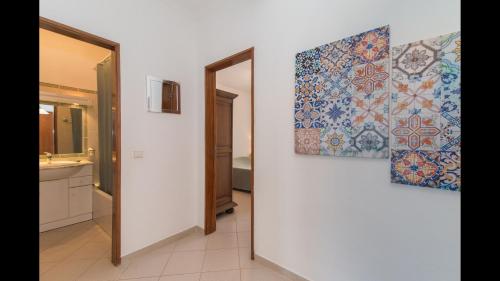 a bathroom with two paintings on the wall at Apt Grace 2 Bedroom Apartment with Pool and Balcony, 2,5km from Tavira Center in Tavira