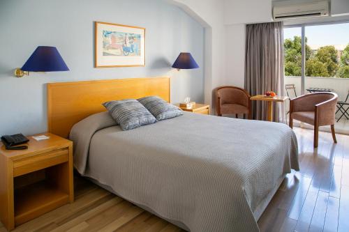 1 dormitorio con 1 cama, mesa y sillas en Cleopatra Hotel en Nicosia