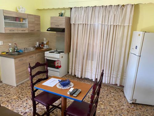 a kitchen with a table and a white refrigerator at Anita's hosting in Kalamata